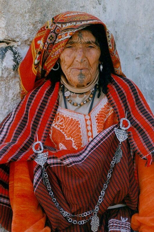 Femme amazighe âgée portant une tenue traditionnelle et des bijoux en argent au Maroc