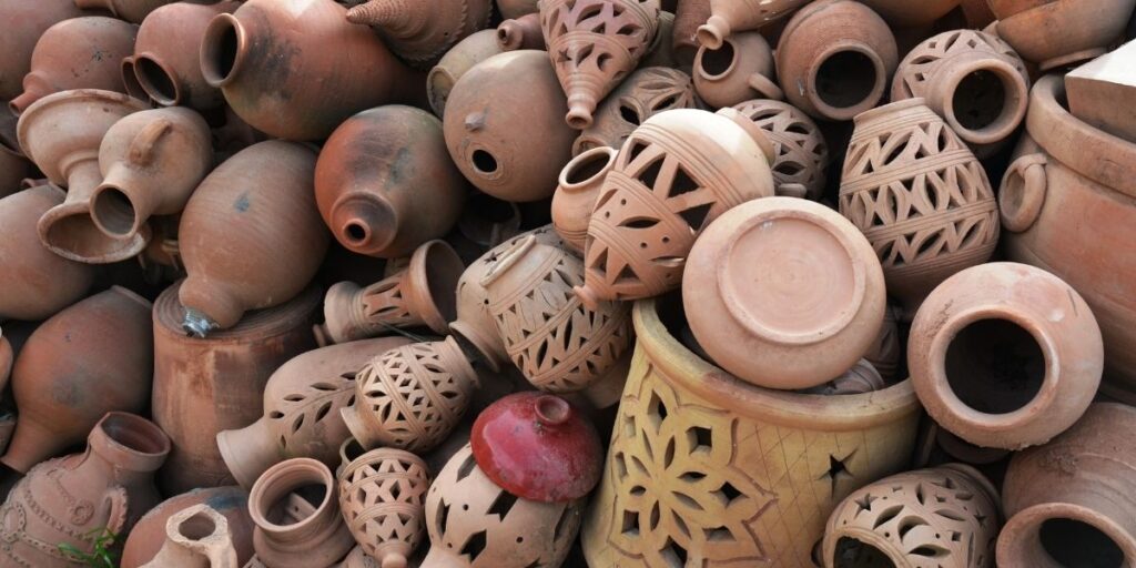 Handcrafted Moroccan pottery made by traditional artisans, featuring terracotta vessels with carved geometric patterns