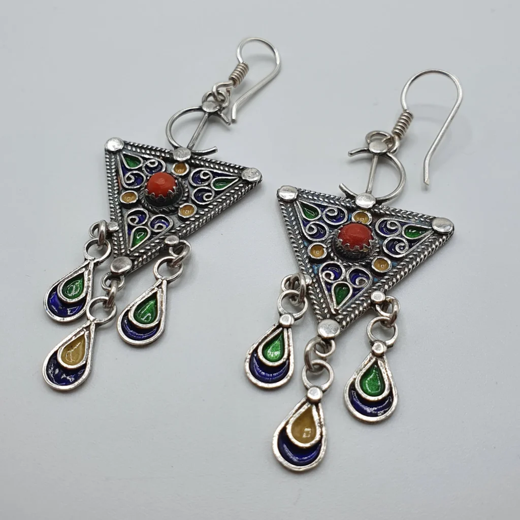 أقراط أمازيغية فضية مثلثة الشكل مزينة بالمينا الملونة وحجر أحمر في الوسط