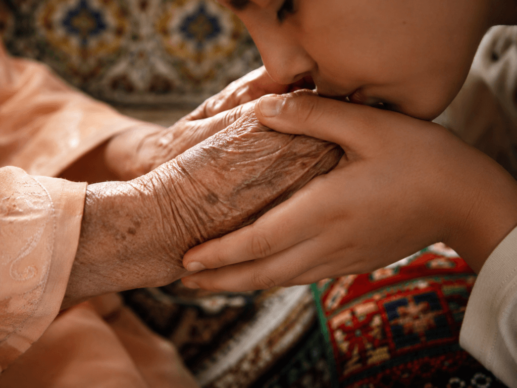 Jeune personne embrassant les mains d’une personne âgée en signe de respect marocain