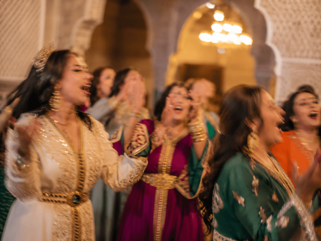 Femmes marocaines en caftans colorés célébrant un moment de joie avec youyou