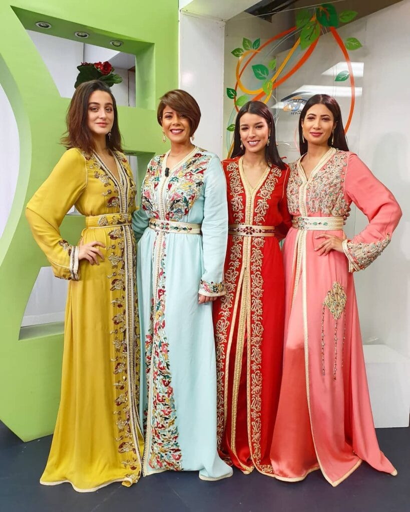 Femmes portant des caftans marocains brodés aux couleurs vives — jaune, turquoise, rouge et rose — tradition et élégance marocaine