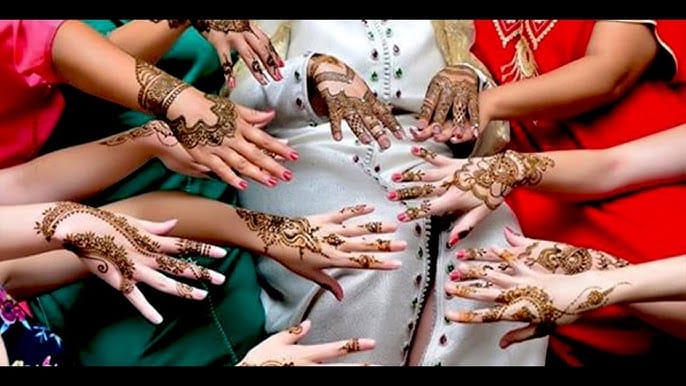 Mains de femmes marocaines décorées de henné réunies lors d'une célébration traditionnelle