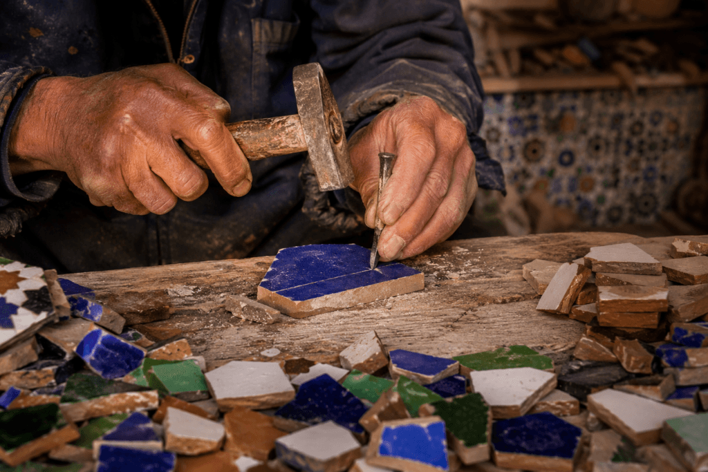 Artisan maâlem taillant le zellige marocain à la main